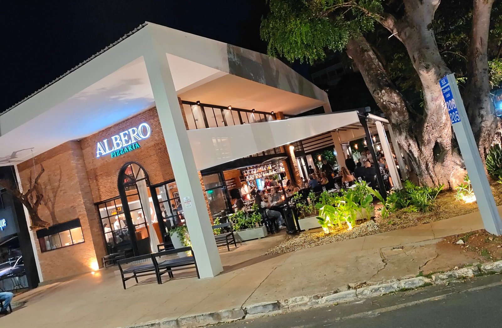 Fachada iluminada da Albero Pizzaria, na 206 Sul.