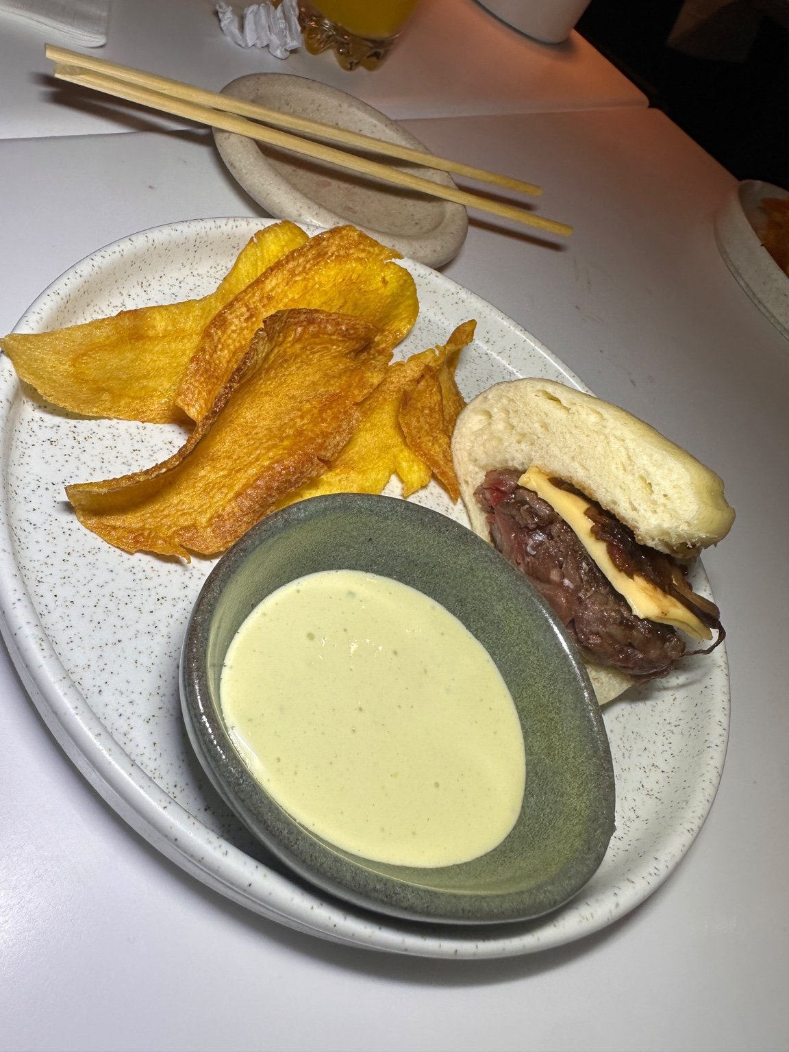 Bun de Wagyu acompanhado de molho e chips.